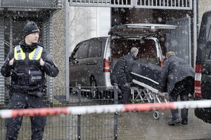 Corpses are carried out of a Jehovah's Witness building and loaded into hearses in Hamburg, Germany Friday, March 10, 2023