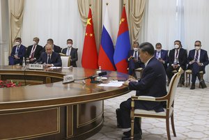 Chinese President Xi Jinping, right, and Russian President Vladimir Putin attend a trilateral meeting with Mongolian President Ukhnaa Khurelsukh on the sidelines of the Shanghai Cooperation Organisation (SCO) summit in Samarkand, Uzbekistan, Thursday, Sept. 15, 2022