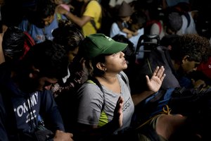 Migrants pray before leaving Escuintla, Chiapas state, Mexico, early Friday, Oct. 29, 2021, as they continue their journey on foot toward the northern states of Mexico and the U.S. border.