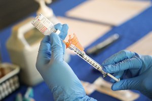 A Jackson-Hinds Comprehensive Health Center nurse prepares a syringe of a Moderna COVID-19 vaccine at an inoculation station next to Jackson State University in Jackson, Miss., Tuesday, July 19, 2022