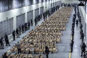 In this photo provided by El Salvador's presidential press office, inmates identified by authorities as gang members are seated on the prison floor of the Terrorism Confinement Center in Tecoluca, El Salvador, Wednesday, March 15, 2023.