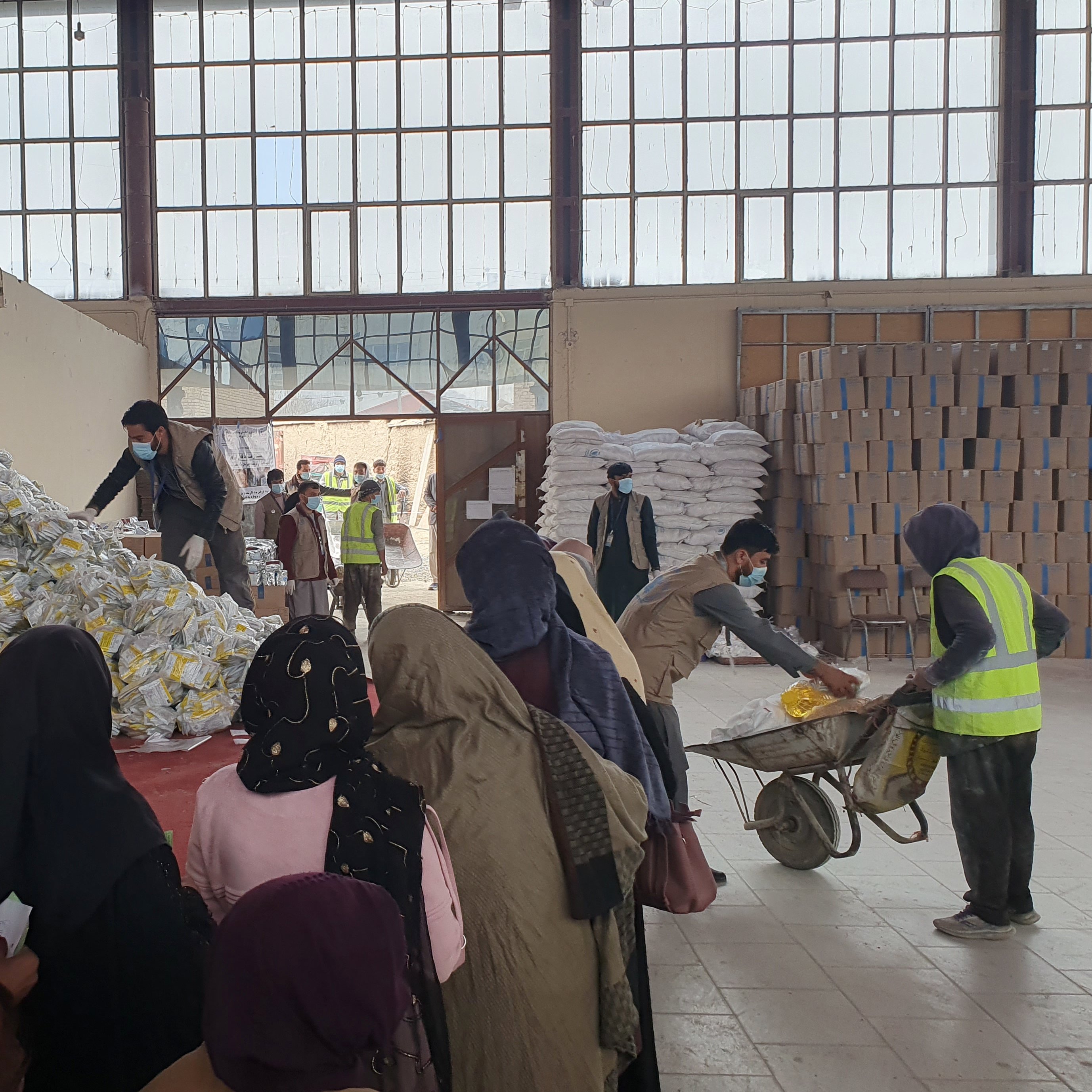 Distribution site in Kabul showing women standing in line to receive in kind food assistance from WFP. 