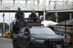 Police from the Dog Action Battalion patrol the Complexo da Mare favela during an operation targeting drug gangs in Rio de Janeiro, Brazil, Monday, Sept. 26, 2022