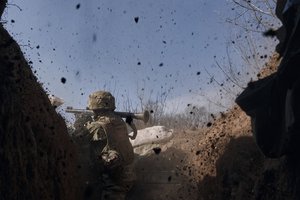 A Ukrainian soldier of the 28th brigade fires a grenade launcher on the frontline during a battle with Russian troops near Bakhmut, Donetsk region, Ukraine, Friday, March 24, 2023