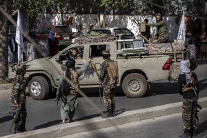 Taliban fighters stand guard at the explosion site, near a mosque, in Kabul, Afghanistan, Friday, Sept. 23, 2022