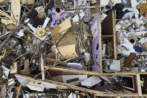 Women, top left, look over a tornado damaged home, Sunday, March 26, 2023, in Rolling Fork