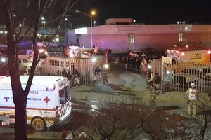 Image taken from a video showing ambulances and rescue teams staffers outside an immigration center in Ciudad Juarez, Mexico, Tuesday, March 28, 2023