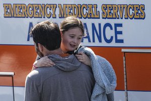 A man carries a child at the reunification center at the Woodmont Baptist church after a school shooting, Monday, March 27, 2023, in Nashville, Tenn.