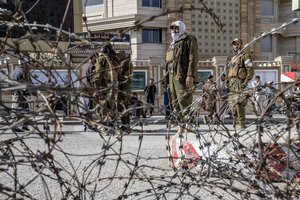 Taliban fighters stand guard at the explosion site, near the Foreign Ministry in Kabul, Afghanistan, Monday, March 27, 2023.