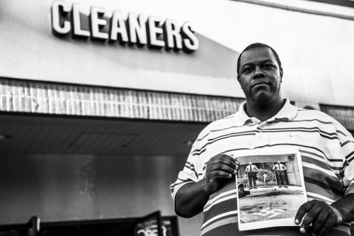 Daryle La,ont Jenkins holds photos of butt-hurt Nazis holding a vigil for George Lincoln Rockwell, in front of the cleaners where he was shot.