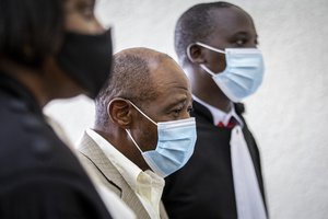 FILE - In this Monday, Sept. 14, 2020 file photo, Paul Rusesabagina, center, whose story inspired the film "Hotel Rwanda" for saving people from genocide, appears at the Kicukiro Primary Court in the capital Kigali, Rwanda.