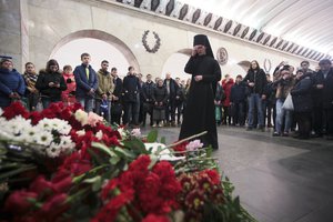 An Orthodox priest blesses at a symbolic memorial at Technologicheskiy Institute metro station, in St. Petersburg, Russia, Tuesday, April 4, 2017.