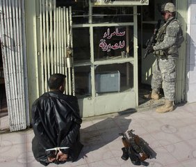 U.S. Army Pvt. Brandon Martin, an infantryman from Bravo Company, 1st Battalion, 505th Parachute Infantry Regiment, 3rd Brigade Combat Team, 82nd Airborne Division, guards a detainee during an operation to disrupt the insurgency's finances Feb. 17, 2007, in Tikrit, Iraq.