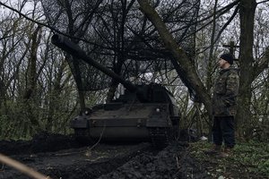 A Ukrainian soldier stands near a German self-propelled Panzerhaubitze 2000 artillery at his position on the frontline in Bakhmut, Donetsk region, Ukraine, Thursday, April 13, 2023