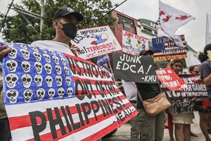 Demonstrators carry placards and shout slogans during a rally in front of Camp Aguinaldo military headquarters in Quezon City, Philippines on Tuesday, April 11, 2023 as they protest against opening ceremonies for the joint military exercise flag called "Balikatan," Tagalog for shoulder-to-shoulder.