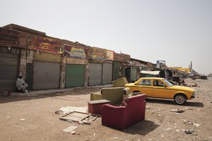 A man sits by shuttered shops in Khartoum, Sudan, Monday, April 17, 2023.