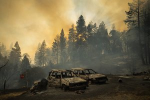 FILE - Scorched vehicles rest in a clearing as the Mosquito Fire burns along Michigan Bluff Rd. in unincorporated Placer County, Calif., Sept. 7, 2022.