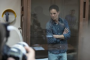 Wall Street Journal reporter Evan Gershkovich stands in a glass cage in a courtroom at the Moscow City Court, in Moscow, Russia, Tuesday, April 18, 2023