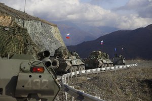 FILE - Russian military vehicles roll along a road towards the separatist region of Nagorno-Karabakh, Friday, Nov. 13, 2020.