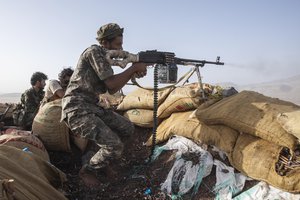 A fighter backed by the Saudi-led coalition fires his weapon during clashes with Houthi rebels on the Kassara frontline near Marib, Yemen