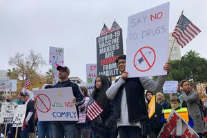 Ron Shindy, left, his 14-year-old daughter, Jezreel Shindy, and their friend Kathy Yates, attend a rally at the state Capitol protesting California's upcoming coronavirus vaccine mandate for school children in Sacramento, Calif