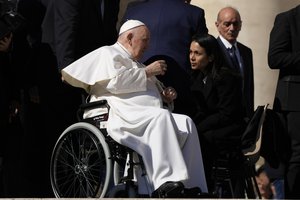 Pope Francis talks with a woman at the end of his weekly general audience in St. Peter's Square at The Vatican, Wednesday, March 15, 2023.