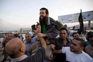 Palestinian Khader Adnan, center, is greeted by Palestinians after his release from an Israeli prison in the West Bank village of Arrabeh near Jenin, Sunday, July 12, 2015