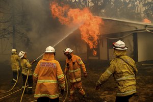 File - Firefighters battle the Morton Fire as it burns a home near Bundanoon, Australia on Jan. 23, 2020. The frequency and duration of droughts will continue to increase due to human-caused climate change, with water scarcity already affecting billions of people across the world, the United Nations warned in a report Wednesday, May 11, 2022.