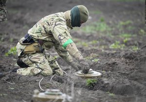 FILE - An interior ministry sapper defuses a mine on a minefield after recent battles in Irpin close to Kyiv, Ukraine, on April 19, 2022. Cyprus is working together with Irish and U.S. military experts to help train two groups of Ukrainian personnel in clearing an untold number of unmarked minefields in their homeland, the island nation's defense minister said Friday May 12, 2023.