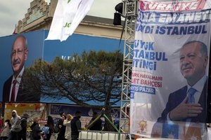 People walk next to billboards of Turkish President and People's Alliance's presidential candidate Recep Tayyip Erdogan, right, and Turkish CHP party leader and Nation Alliance's presidential candidate Kemal Kilicdaroglu in Istanbul, Turkey, Thursday, May 11, 2023