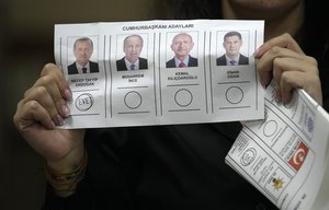 An election representative shows a ballot depicting a vote for President Recep Tayyip Erdogan at a polling station in Istanbul, Turkey