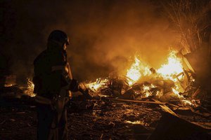 In this photo provided by the Ukrainian Emergency Situations Ministry, firefighters put out fire caused by fragments of a Russian rocket after it was shot down by air defense system during the night Russian rocket attack in Kyiv, Ukraine, early Tuesday, May 16, 2023.