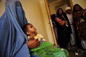 Afghan mothers wait to receive food for their children at the Supplemental Feeding Program at Farah Hospital in Farah, Afghanistan, May 22