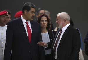 Brazilian President Luiz Inacio Lula da Silva, right, talks with Venezuela's President Nicolas Maduro, with a translator standing between them as they leave Itamaraty Palace in Brasilia, Brazil, Monday, May 29, 2023