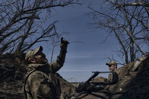 A Ukrainian soldier points at a Russian drone from a trench on the frontline in Bakhmut, Donetsk region, Ukraine, Monday, April 10, 2023