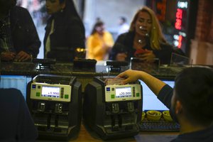 A worker counts Turkish liras banknotes in an exchange currency shop in Istanbul, Turkey