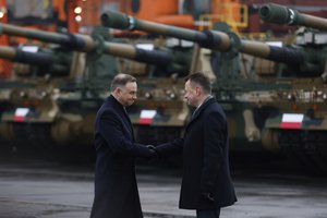 Poland's president Andrzej Duda, left, and Polish Minister of Defense Mariusz Blaszczak, right, shake hands during a press conference in the Polish Navy port of Gdynia, Poland, Tuesday, Dec. 6, 2022