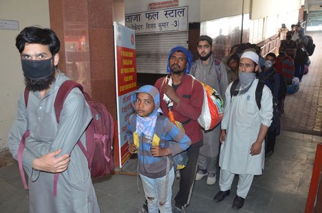 The temperature of stranded passengers is being checked at the general bus stand during a lockdown in Jammu, India, 25 March 2020.