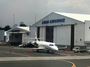 A small plane is parked outside the Asian Aerospace hangar.