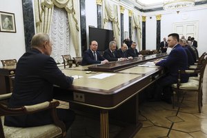 Vladimir Putin, back to the camera, chairs a Security Council meeting in Moscow, Russia