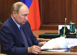 Russian President Vladimir Putin listens to Volgograd Region Governor Andrei Bocharov during their meeting in Moscow, Russia, Wednesday, Sept. 28, 2022