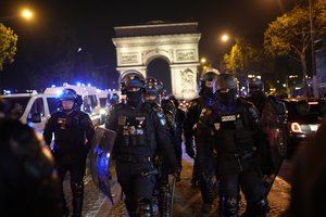 Police officers patrol in front of the Arc de Triomphe on the Champs Elysees in Paris, Saturday, July 1, 2023. President Emmanuel Macron on Saturday scrapped an official trip to Germany after a fourth straight night of rioting and looting across France in defiance of a massive police deployment. Hundreds turned out for the burial of the 17-year-old whose killing by police triggered the unrest.