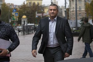 Crimean leader Sergei Aksyonov walks to his car after a news conference in Moscow, Russia, Thursday, Oct. 16, 2014