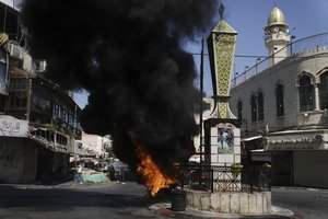 Tires burn during an Israeli military raid in the militant stronghold of Jenin refugee camp in the occupied West Bank, Monday, July 3, 2023. Israeli drones struck targets in the area early Monday and hundreds of troops were deployed. Palestinian health officials said at least five Palestinians were killed.