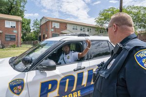 Baltimore police coordinate in the area of a mass shooting incident in the Southern District of Baltimore, Monday, July 3, 2023. Police say at least 2 people were killed and multiple others were wounded in a shooting that took place during a block party just after midnight on Sunday.