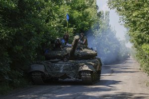 Ukrainian servicemen ride atop on a tank T-64 at the front line near Bakhmut, Donetsk region, Ukraine, Monday, July 3, 2023.