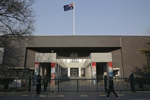 FILE - In this Jan. 24, 2019, file photo, a woman walks by the Australian Embassy in Beijing