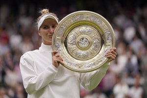 Marketa Vondrousova celebrates with the trophy after beating Ons Jabeur to win the final