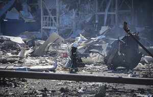 An Ukrainian firefighter works near a destroyed building on the outskirts of Odesa, Ukraine, Tuesday, May 10, 2022. The Ukrainian military said Russian forces fired seven missiles a day earlier from the air at the crucial Black Sea port of Odesa, hitting a shopping center and a warehouse.