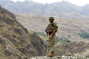 A Pakistan army soldier stands guard in Pakistani tribal area of Khyber near  Torkham border post between Pakistan and Afghanistan, Wednesday, June 15, 2016.